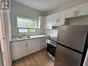 Toronto (Annex) multi-family for rent - A kitchen with white cabinets and a stainless steel refrigerator.