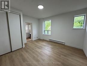 Toronto (Annex) multi-family for rent - A spacious room with wooden flooring and white walls.