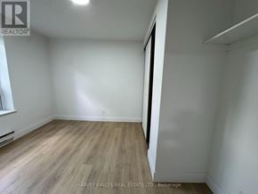 Toronto (Annex) multi-family for rent - A room with wooden flooring and white walls, with a window on the left side.