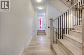 Oakville townhouse for rent - A hallway with a staircase and a red cross on the wall.
