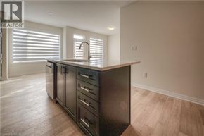 Oakville townhouse for rent - A modern kitchen with dark wood cabinets and a white countertop.