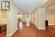 Brampton (Snelgrove) apartment for rent - A hallway with wood floors and white walls leading to a door.