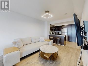 Markham (Commerce Valley) condo for rent - A modern living room with a white sofa and a wooden coffee table.