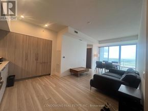 Toronto (Waterfront Communities) condo for rent - A living room with a black couch and wooden floors.