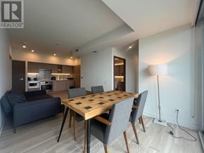 Toronto (Waterfront Communities) condo for rent - A modern dining room with a wooden table and grey chairs.