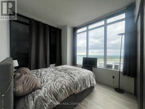 Toronto (Waterfront Communities) condo for rent - A bedroom with a large bed and a view of the water.