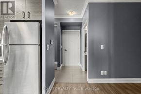 Markham (Unionville) condo for rent - A modern kitchen with a stainless steel refrigerator and a hallway leading to a door.