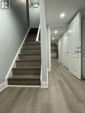 Milton (Wi Willmott) townhouse for rent - A hallway with a staircase and doors on the right side.