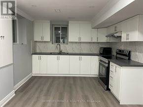 Milton (Wi Willmott) townhouse for rent - A kitchen with white cabinets and a black stove top oven.