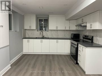 Milton (Wi Willmott) townhouse for rent - A kitchen with white cabinets and a black stove top oven.