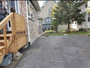 Oshawa (Central) apartment for rent - A backyard with a wooden deck and a tree.