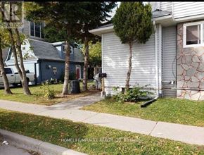 Oshawa (Central) apartment for rent - A tree in front of a grey house.