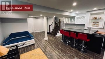 Markham (Wismer) apartment for rent - A furnished unit with a bed, bar stools, and a kitchenette.