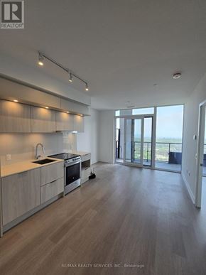 Mississauga (City Centre) condo for rent - A modern kitchen with wooden floors and a large window.