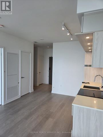 Mississauga (City Centre) condo for rent - A modern kitchen with white cabinets and a wooden countertop.