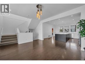 Coquitlam apartment for rent - A spacious living room with a staircase and a kitchen area.