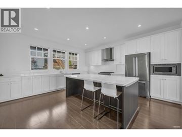 Coquitlam apartment for rent - A modern kitchen with white cabinets and a large island.