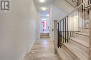 Oakville (Go Glenorchy) townhouse for rent - A hallway with a staircase and a red cross on the wall.