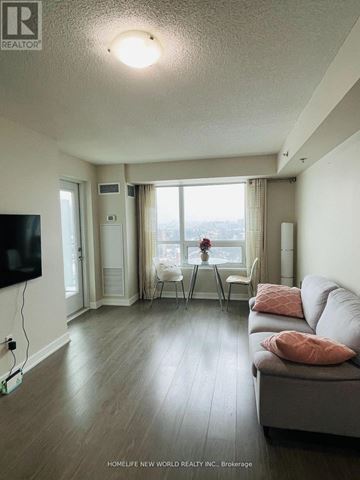 Toronto (Tam O'shanter-Sullivan) condo for rent - A living room with a grey couch and a television on the wall.
