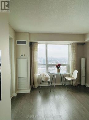Toronto (Tam O'shanter-Sullivan) condo for rent - A modern dining room with a glass table and chairs.