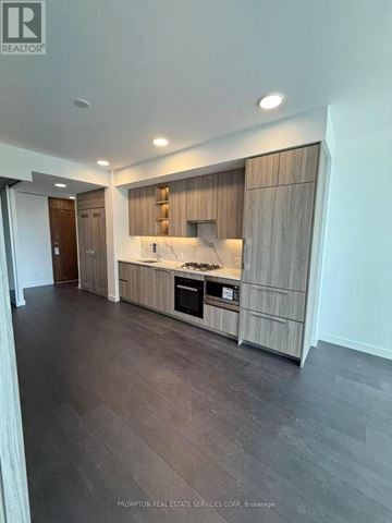 Toronto (Bayview Village) condo for rent - A modern kitchen with dark wood floors and a marble countertop.