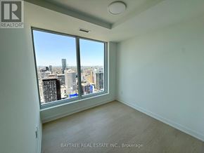 Toronto (Church-Yonge Corridor) condo for rent - A room with a view of the city skyline through a large window.
