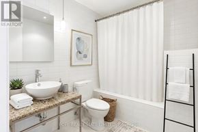 Toronto (Waterfront Communities) condo for rent - A bathroom with a sink, toilet, and a white shower curtain.
