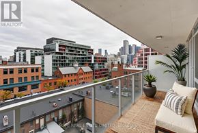 Toronto (Waterfront Communities) condo for rent - A balcony with a couch and pillows overlooks a cityscape.