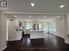 Hamilton (Dundas) apartment for rent - A spacious kitchen and living room with white cabinetry and dark hardwood floors.
