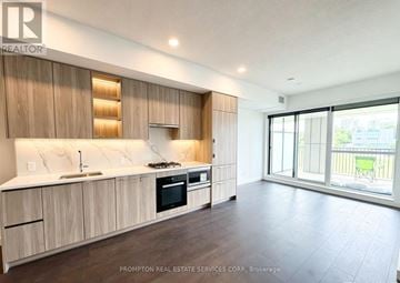Toronto (Bayview Village) condo for rent - A kitchen with wooden cabinets and a countertop with a sink and stove.