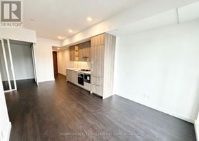 Toronto (Bayview Village) condo for rent - A spacious room with a kitchenette and wooden flooring.