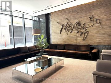Toronto (Church-Yonge Corridor) condo for rent - A modern living room with a glass coffee table and a large abstract sculpture on the wall.