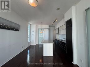 Toronto (Church-Yonge Corridor) condo for rent - A spacious kitchen with dark wood floors and white cabinetry.