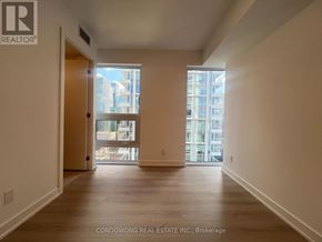 Toronto (Church-Yonge Corridor) condo for rent - A spacious room with wooden floors and a view of a cityscape through the windows.