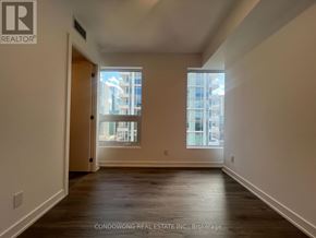 Toronto (Church-Yonge Corridor) condo for rent - A room with wooden floors and a window showing a view of a building outside.