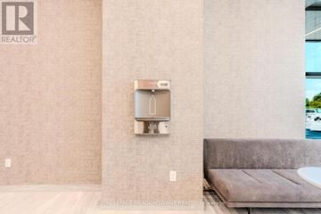 Mississauga (Central Erin Mills) condo for rent - A modern living room with a grey sofa and a wall-mounted TV.