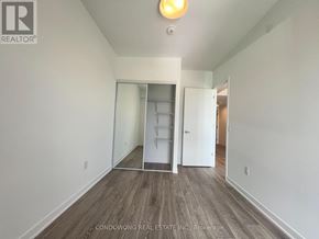 Toronto (Regent Park) condo for rent - A room with a white wall and a wooden floor with a sliding door.