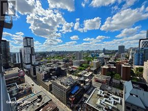Toronto (Waterfront Communities) condo for rent - A cityscape with buildings and a cloudy sky.