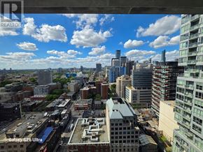 Toronto (Waterfront Communities) condo for rent - A cityscape with a mix of modern and older buildings, viewed from a high vantage point.