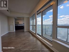 Toronto (Waterfront Communities) condo for rent - A room with wooden floors and large windows overlooking a cityscape.