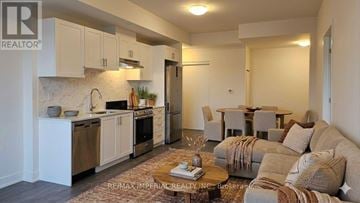 Newmarket (Huron Heights-Leslie Valley) condo for rent - A well-lit, modern kitchen and living room with a sofa and coffee table.