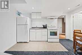 Markham (Old Markham Village) apartment for rent - A white kitchen with a refrigerator, cabinets, and a stove top oven.