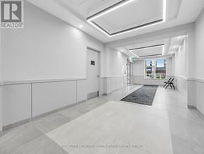 Toronto (Scarborough Village) condo for rent - A spacious hallway with a rug on the floor and a door at the end.