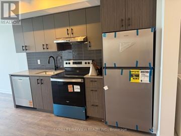 Burlington (Appleby) condo for rent - A kitchen with a refrigerator covered in blue tape.