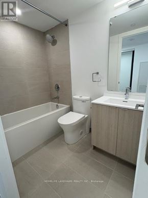 Toronto (Church-Yonge Corridor) condo for rent - A white toilet sits next to a white bathtub in a bathroom.