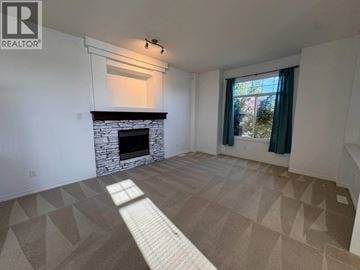 Maple Ridge apartment for rent - A living room with a fireplace and a carpet with triangular patterns.