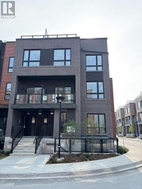 Newmarket (Glenway Estates) townhouse for rent - A modern brick building with a black gate in front.