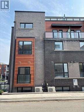 Newmarket (Glenway Estates) townhouse for rent - A modern building with a mix of brick and wood paneling.