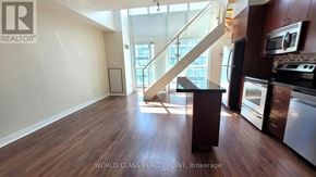 Toronto (Mimico) condo for rent - A realtor logo is on a wall in a spacious kitchen.