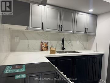Milton (De Dempsey) apartment for rent - A kitchen with black cabinets and a white countertop.